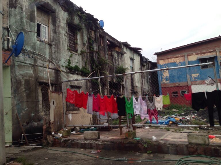 Poverty illustrated; drying clothes hanging by eroded paint building grounds