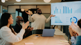A-young-happy-male-pitching-an-idea-in-front-of-a-teamhow-to-pitch-ideas